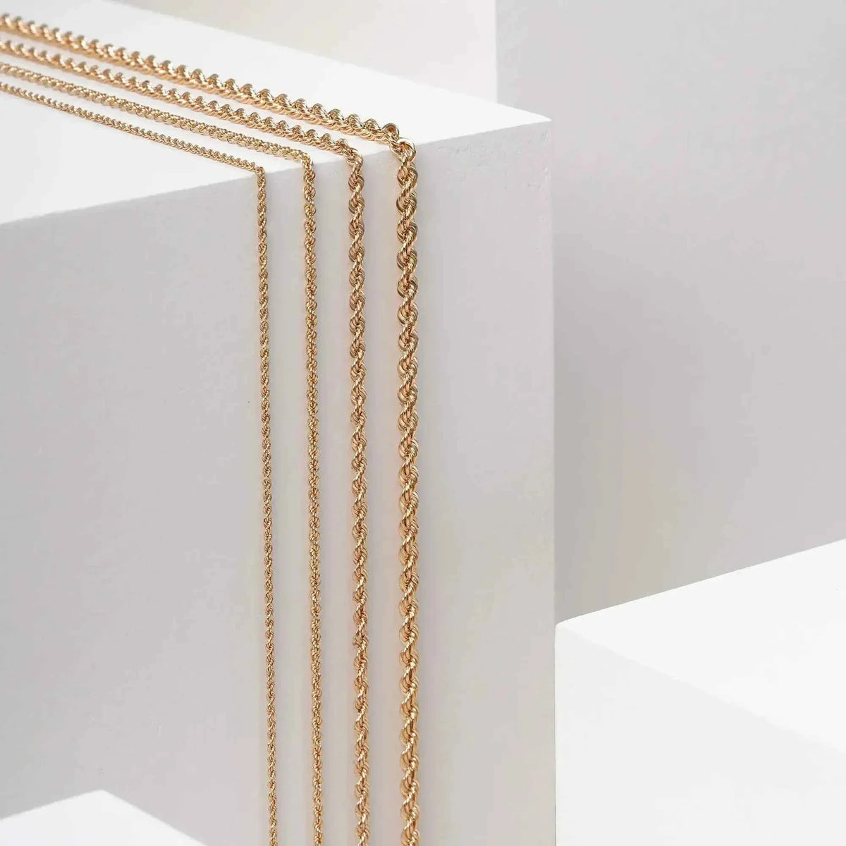 14K gold rope chain necklaces in several widths on display blocks