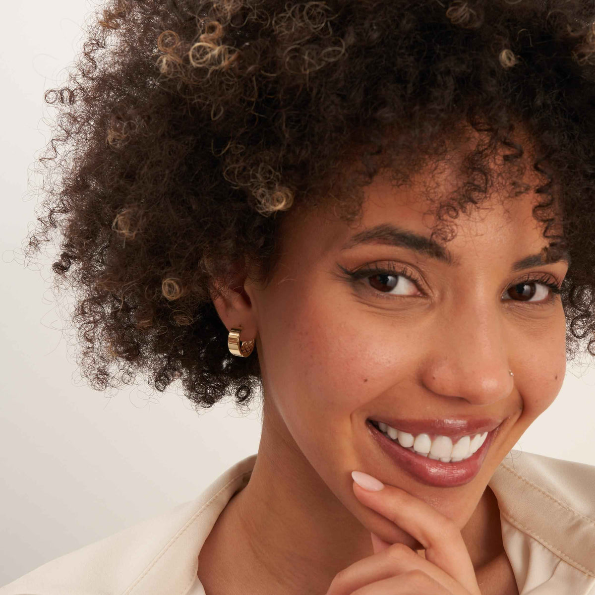 Model wearing 14K gold thick huggie earrings