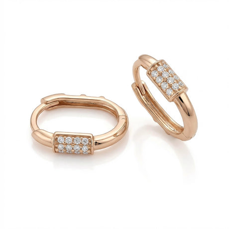 Paire de créoles huggie ovales pavées d'oxydes de zirconium en or rose 14 carats sur fond blanc