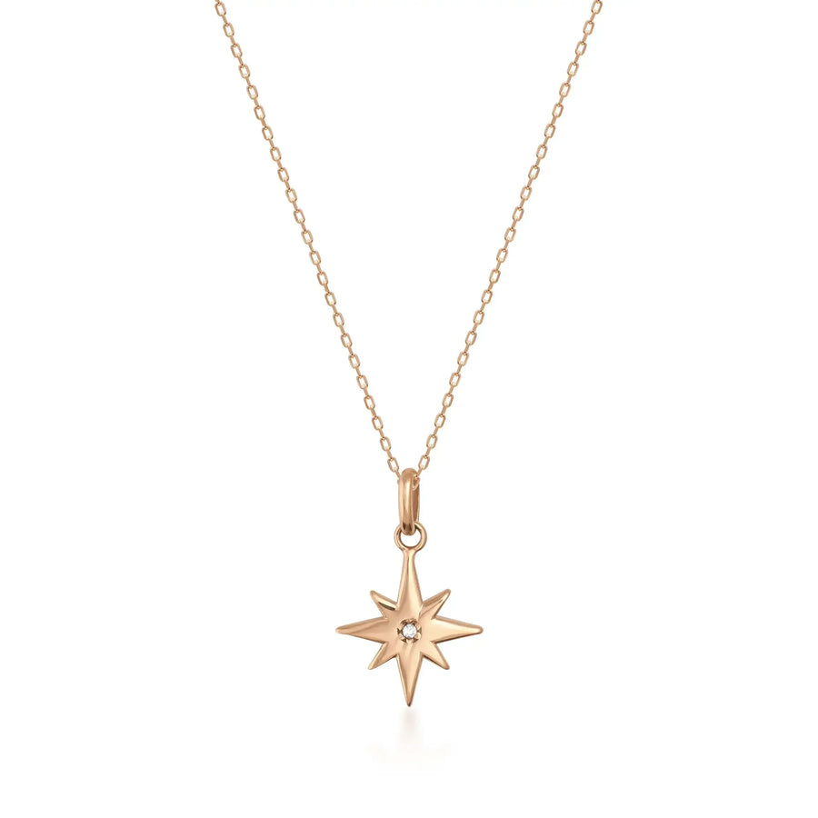 Collar con colgante de estrella polar con circonita central en oro rosa de 14 quilates sobre fondo blanco