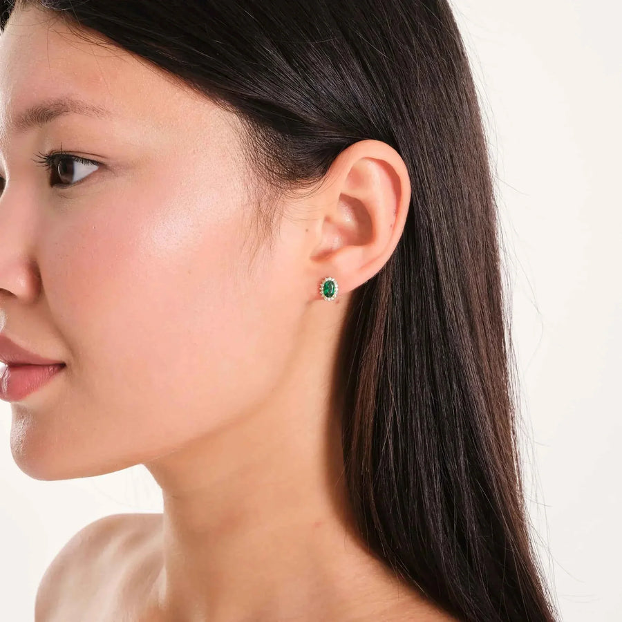 Puce d'oreille halo émeraude de synthèse en or 14 carats portée par un mannequin, de profil