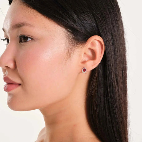 Puce d'oreille halo rubis de synthèse en or 14 carats portée par un mannequin, de profil