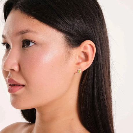 Puce d'oreille halo citrine de synthèse en or 14 carats portée par un mannequin, visage de trois quarts