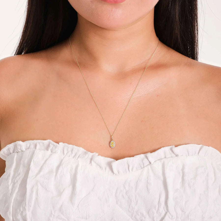 Collana con ciondolo halo in oro giallo 14kt con citrino creato in laboratorio indossata da una modella con top bianco a spalle scoperte