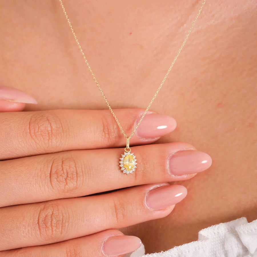 Collana con ciondolo halo in oro giallo 14kt con citrino creato in laboratorio, indossata e tenuta tra le dita