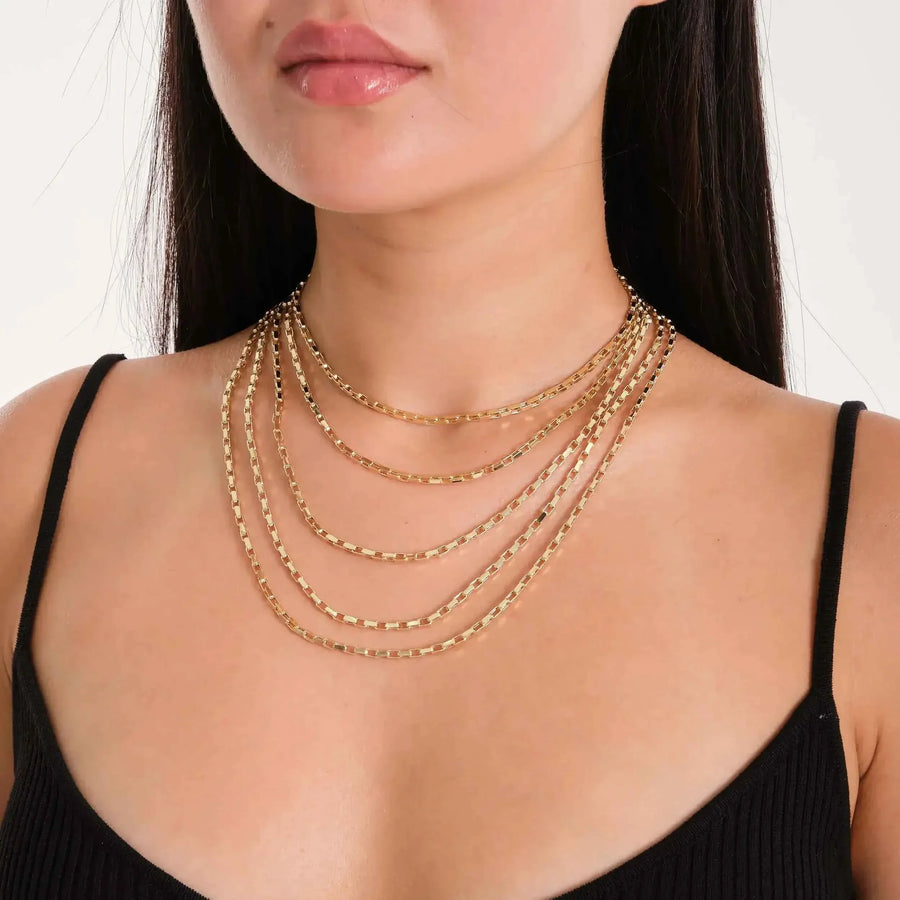 Flache Paperclip-Ketten aus 585er Gelbgold im Layering-Look am Model mit schwarzem Top