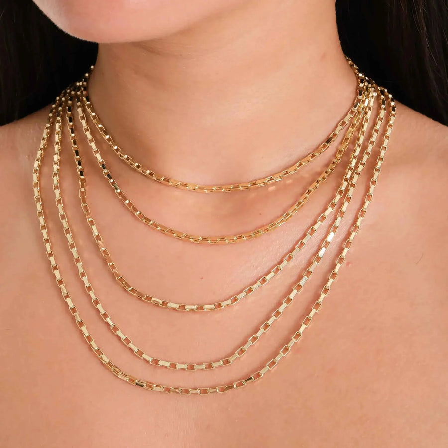 Nahaufnahme: flache Paperclip-Ketten aus 585er Gelbgold im Layering-Look am Hals