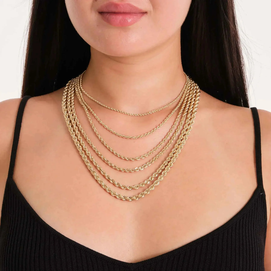 14K yellow gold rope chain necklaces layered on model in black top