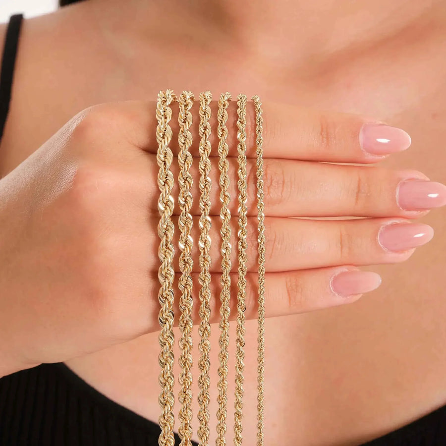 14K yellow gold rope chain necklaces in several widths draped over hand