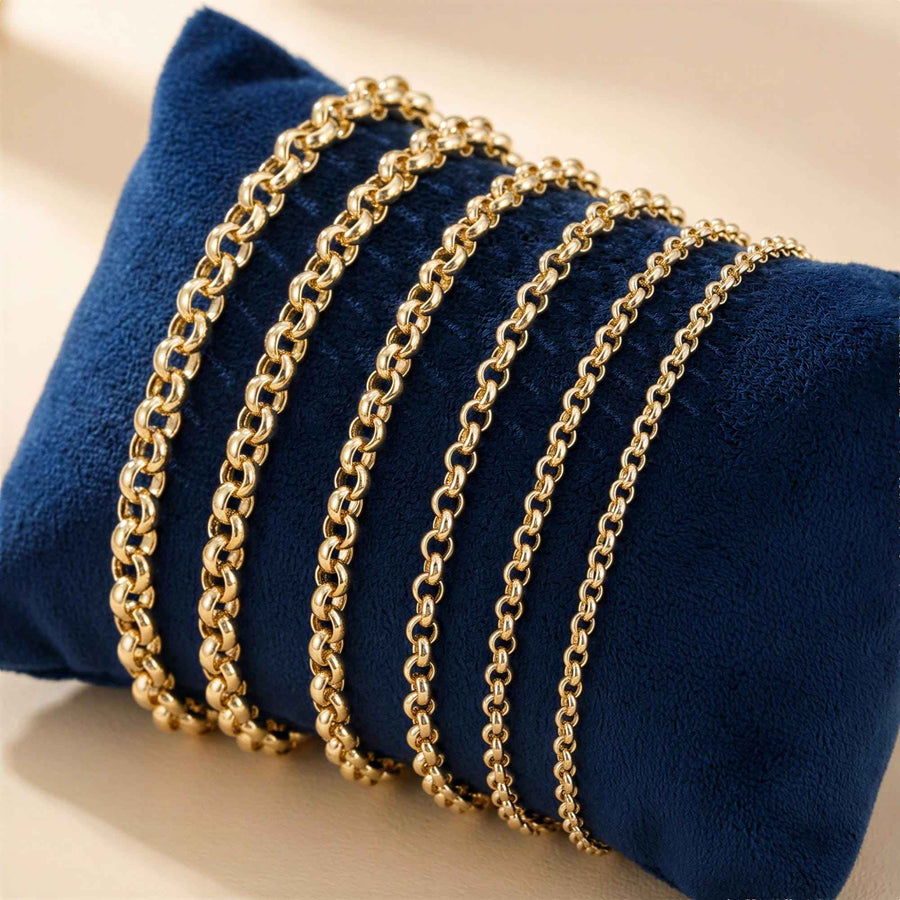 Bracelets maille rolo en or jaune 14 carats de plusieurs largeurs sur un coussin de présentation en velours bleu marine