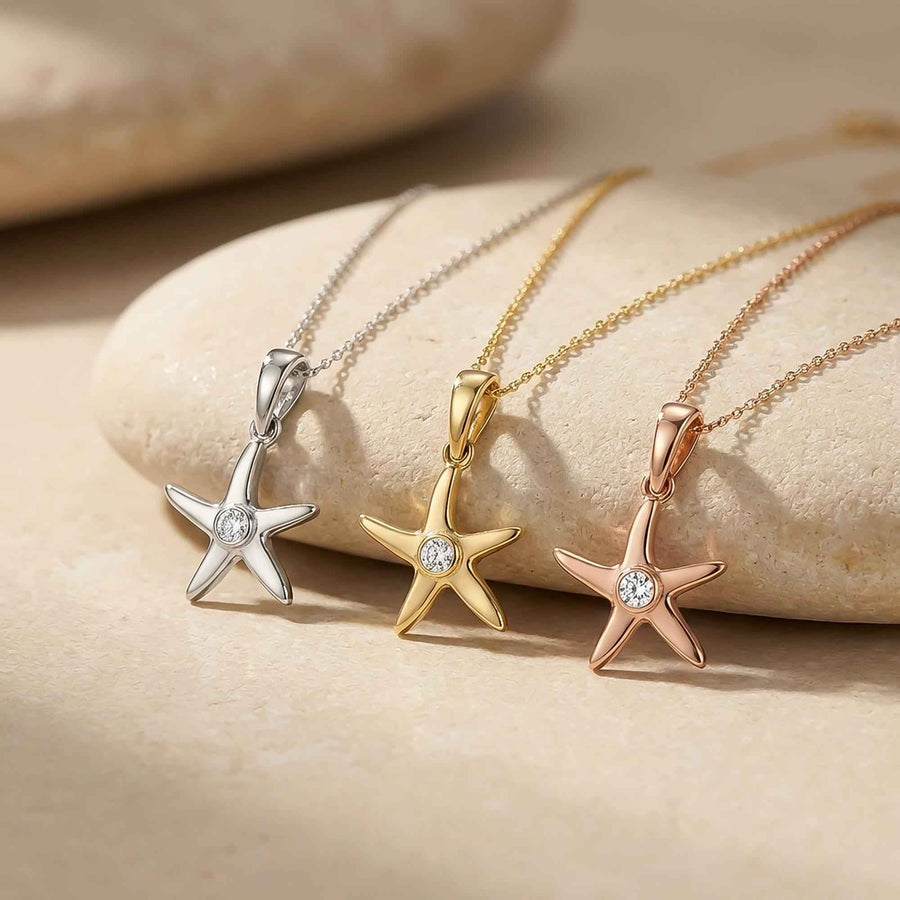 Pendentifs étoile de mer en or jaune, blanc et rose 14 carats drapés sur une pierre beige lisse