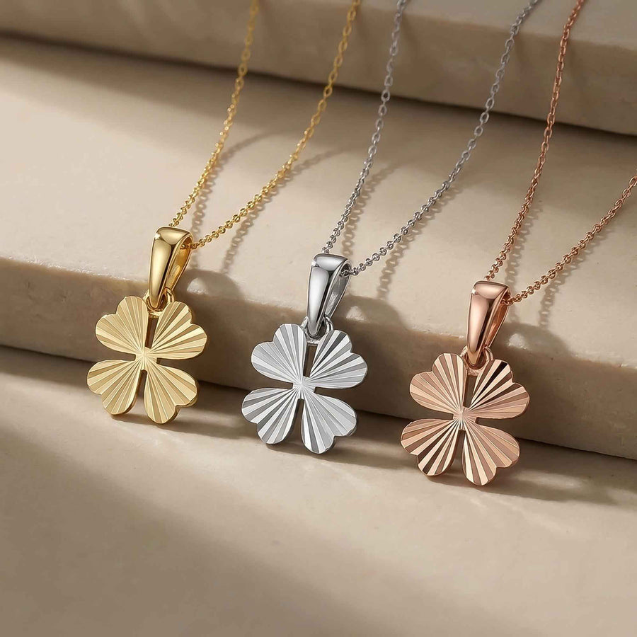 Pendentifs trèfle à quatre feuilles taille diamant en or jaune, blanc et rose 14 carats suspendus à un rebord en pierre