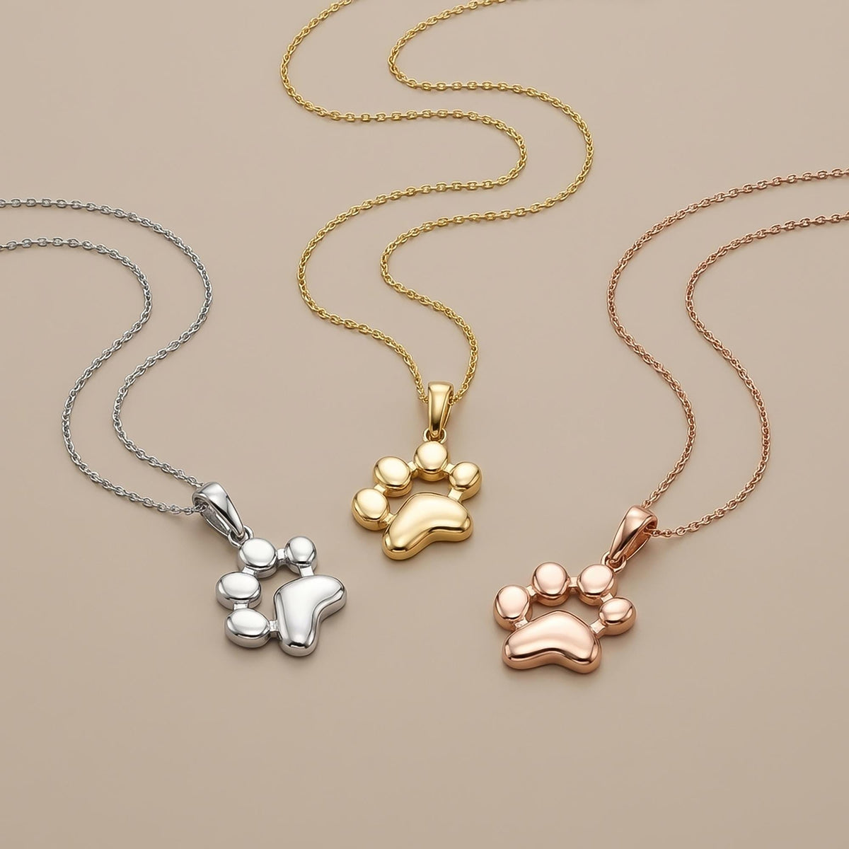 Colliers empreinte de patte en or blanc, jaune et rose 14 carats sur fond beige