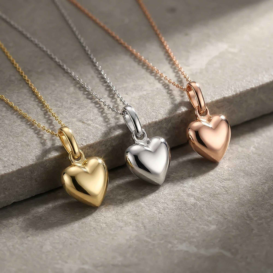 Colliers cœur bombé 3D en or jaune, blanc et rose 14 carats sur une pierre grise, gros plan