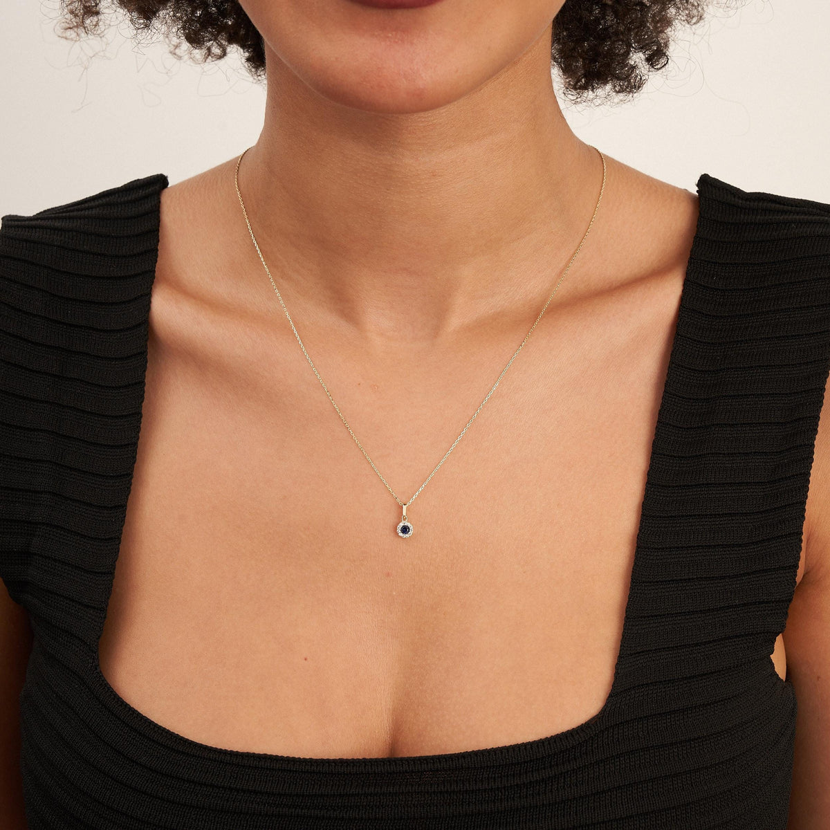 Collier halo saphir rond de synthèse en or jaune 14 carats porté par un mannequin, vue de face