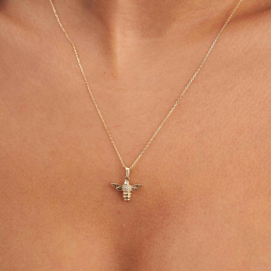 Collier pendentif abeille en or 14 carats porté au centre de la clavicule