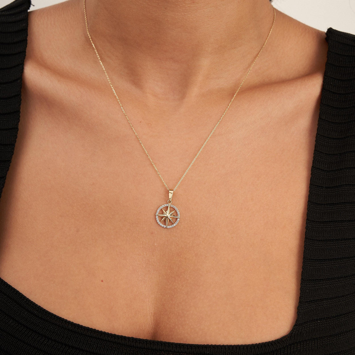 14K yellow gold compass star necklace worn on model, front view