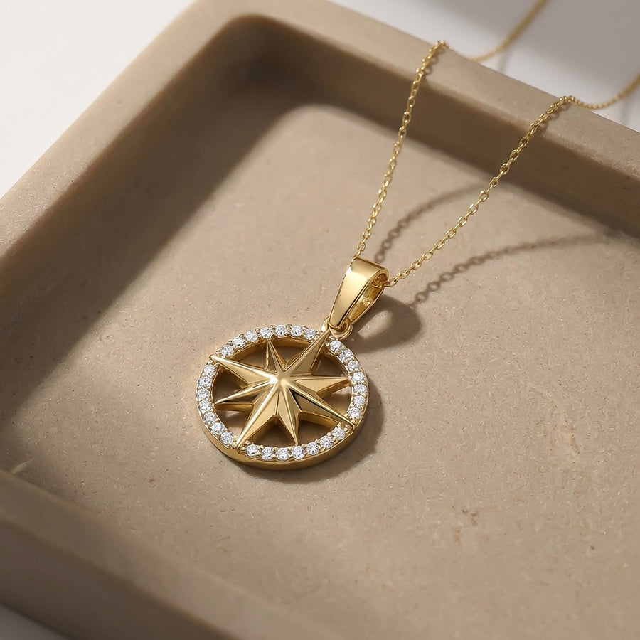 14K yellow gold compass star pendant with CZ ring in a stone dish