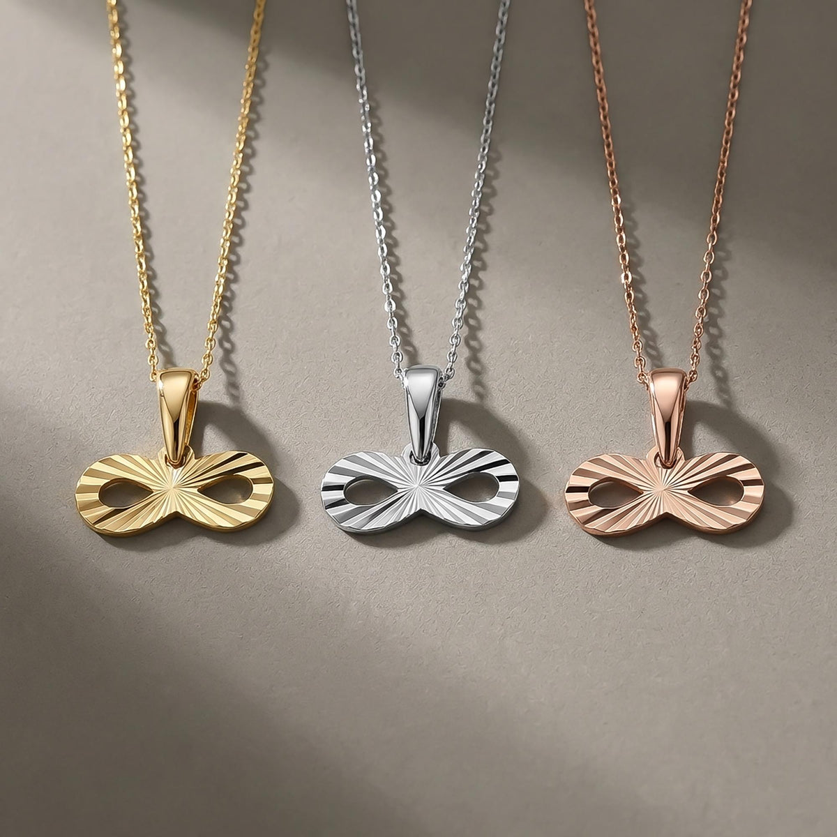 14K yellow, white and rose gold diamond-cut infinity pendants side by side