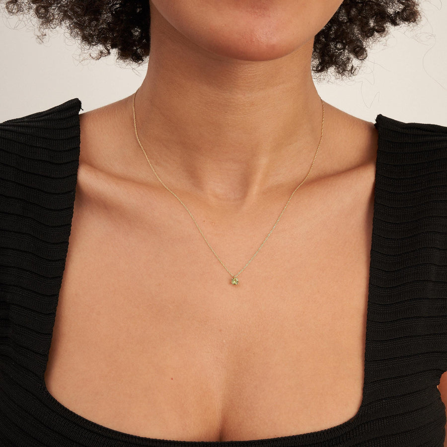 Collar solitario de citrino en oro amarillo de 14 quilates llevado por la modelo con top negro
