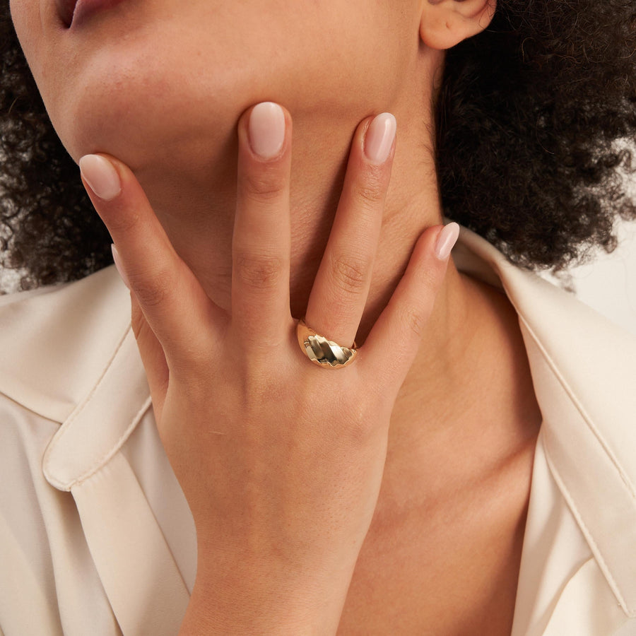 Swirl-Kuppelring aus 585er Gelbgold an der Hand unter dem Kinn des Models