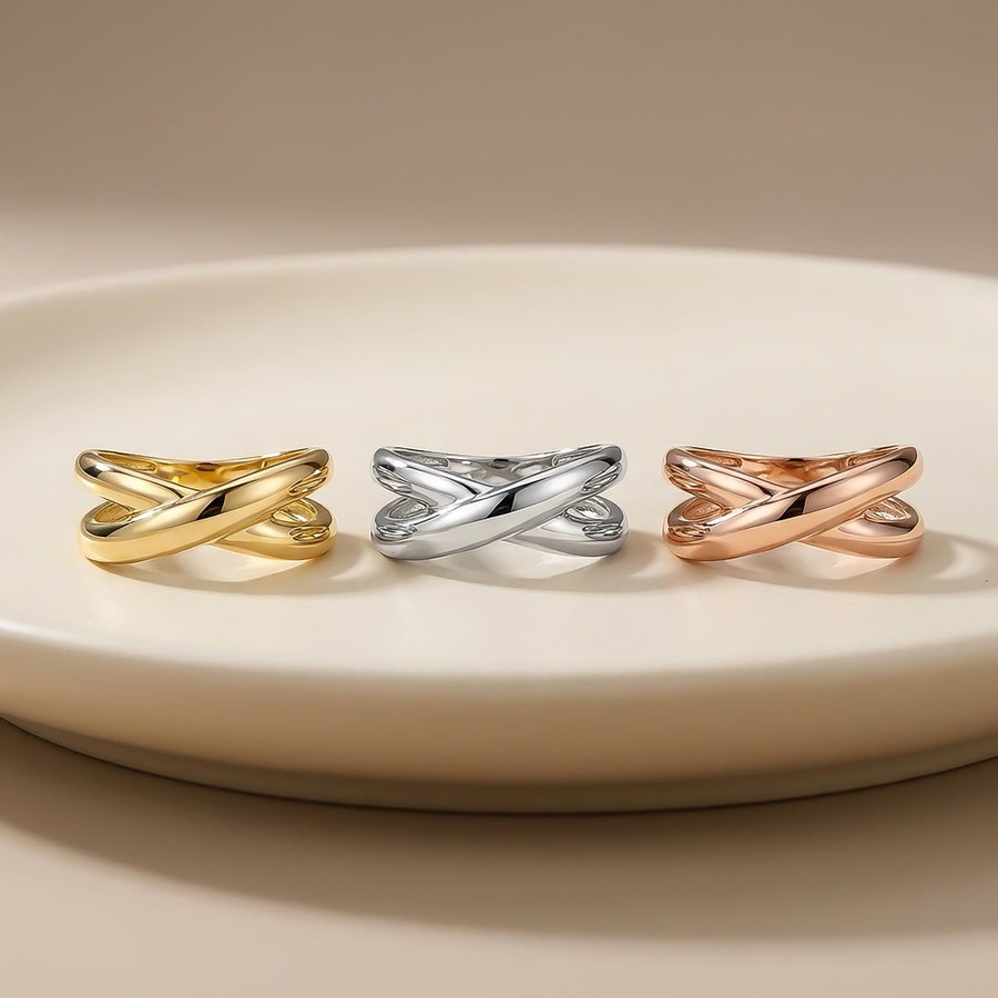 Anillos cruzados en oro amarillo, blanco y rosa de 14 quilates sobre un plato blanco