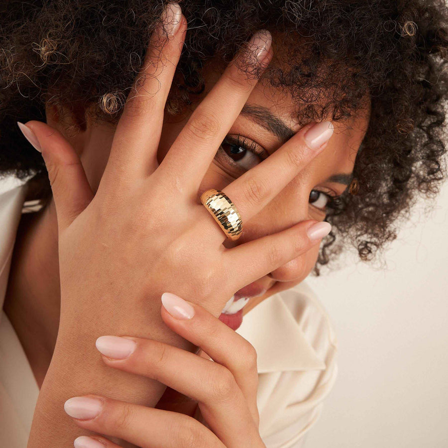 Model mit der Hand vor dem Gesicht, trägt einen diamantierten Kuppelring aus 585er Gelbgold