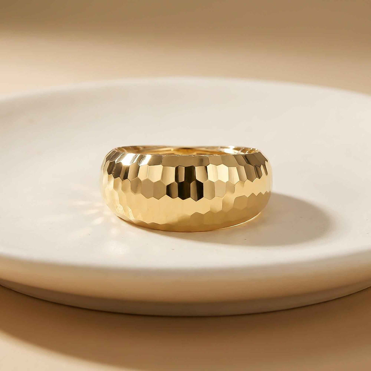 Diamantierter Kuppelring aus 585er Gelbgold auf einem weißen Teller