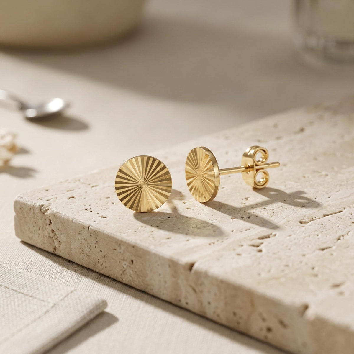 Paar Sonnenstrahl-Ohrstecker aus 585er Gelbgold auf Travertin