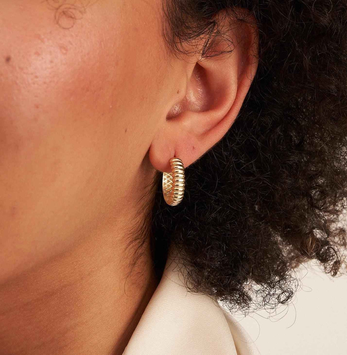 Nahaufnahme: Ohr mit gerippter Croissant-Creole aus 585er Gelbgold