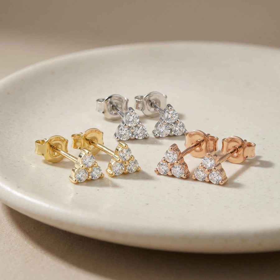 Orecchini a lobo triangolari con zirconi a grappolo in oro giallo, bianco e rosa 14kt su un piatto di ceramica