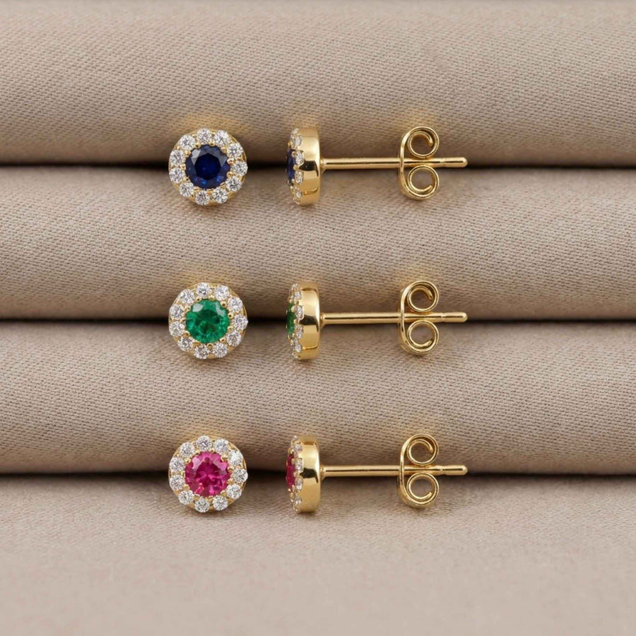 Edelstein-Halo-Ohrstecker aus 585er Gelbgold mit laborgezüchtetem Saphir, Smaragd und Rubin auf gefaltetem Stoff