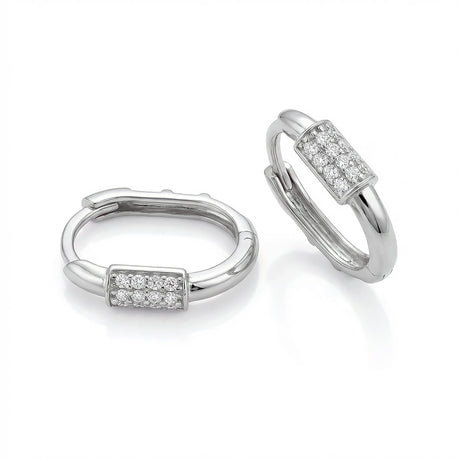 Paire de créoles huggie ovales pavées d'oxydes de zirconium en or blanc 14 carats sur fond blanc