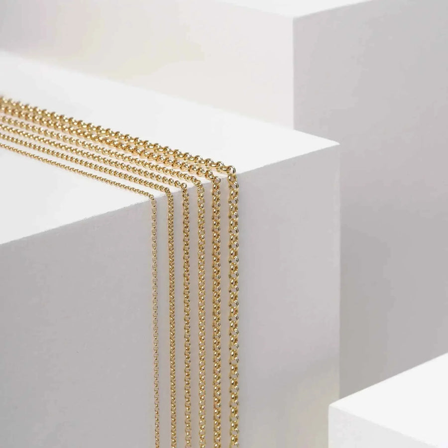 Cadenas rolo en oro amarillo de 14 quilates sobre bloques expositores blancos