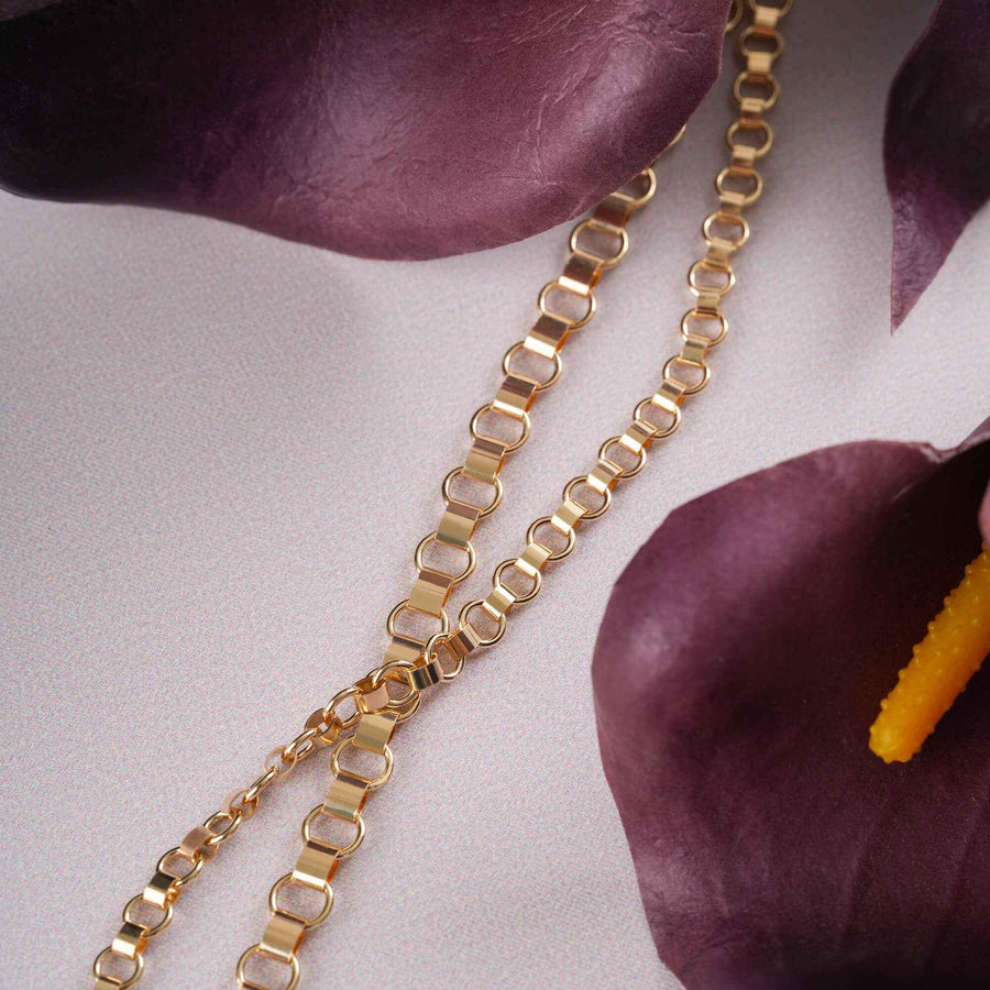 Chaîne maille vénitienne arrondie en or jaune 14 carats mise en scène avec des callas violet foncé