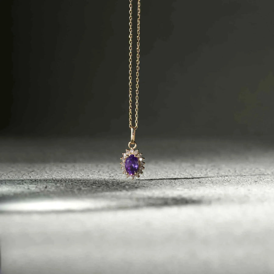 Collana con ciondolo halo in oro giallo 14kt con ametista creata in laboratorio, sospesa su una superficie scura texturizzata