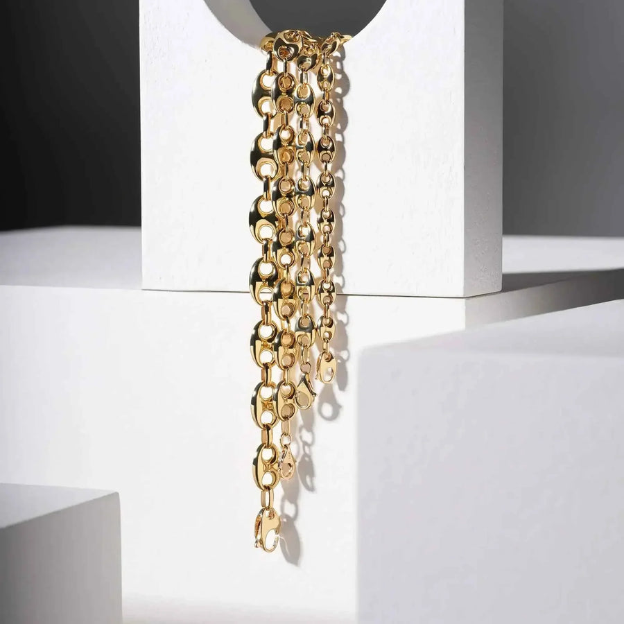 Bracciali a maglia marina in oro giallo 14kt appesi a un espositore bianco