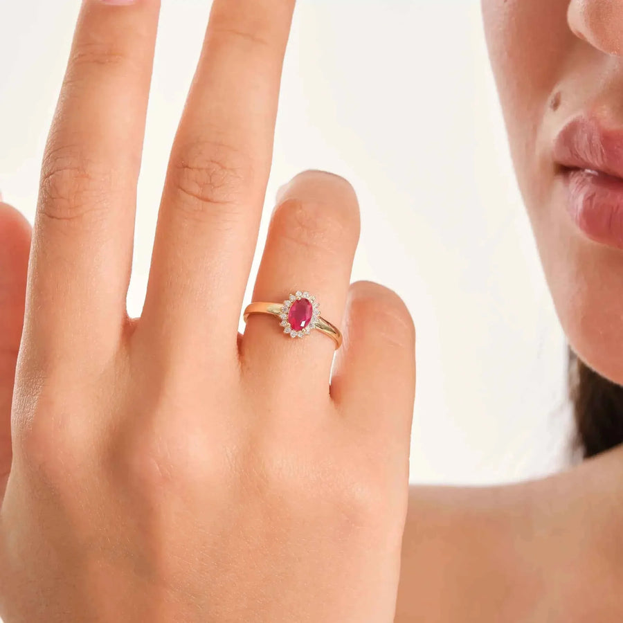 Bague pierre de naissance halo rubis de synthèse en or 14 carats portée au doigt, vue du dos de la main