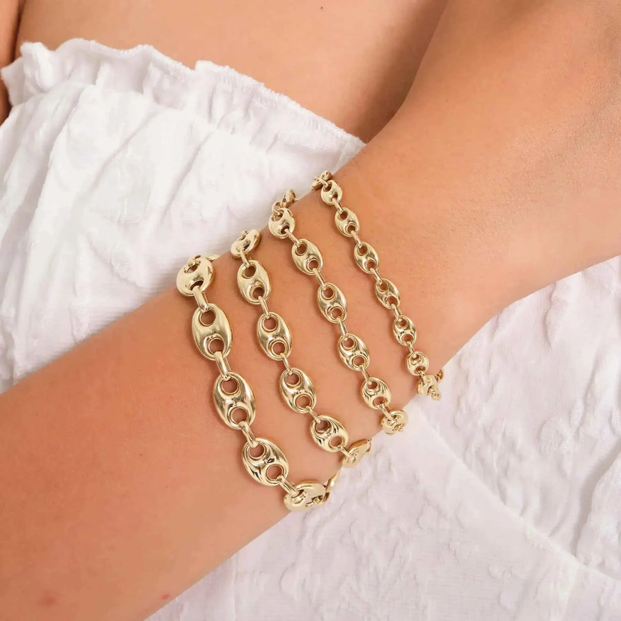 Primo piano dei bracciali a maglia marina in oro giallo 14kt indossati sovrapposti al polso