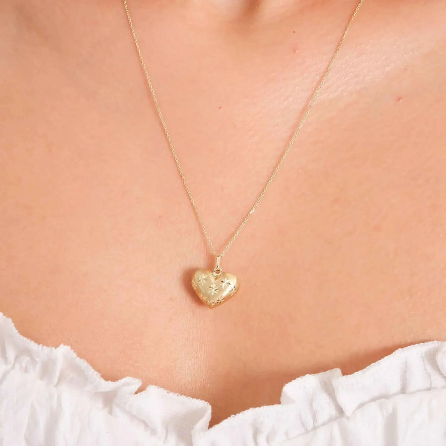 Primo piano della collana cuore bombato con stella incisa in oro giallo 14kt indossata al collo
