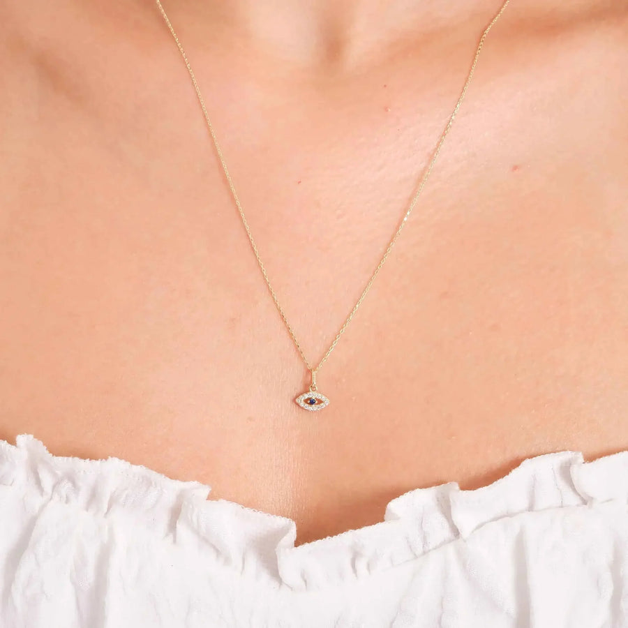 Primo piano della collana occhio turco in oro giallo 14kt con zaffiro blu creato in laboratorio indossata al collo