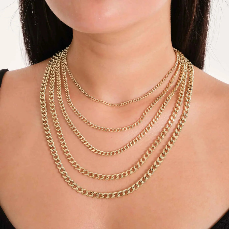 Primer plano de cadenas cubanas Miami en oro amarillo de 14 quilates superpuestas en el cuello