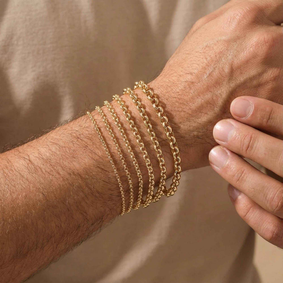 Bracelets maille rolo en or jaune 14 carats superposés, portés au poignet d'un homme