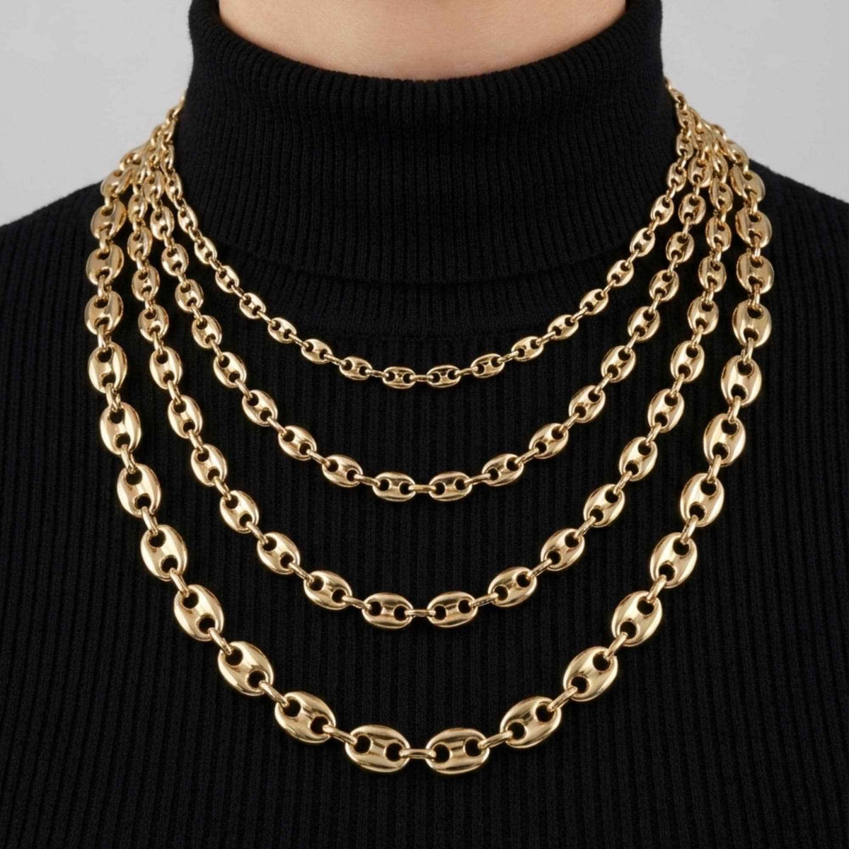 Collane a maglia marina in oro giallo 14kt in quattro larghezze, a strati su un dolcevita nero