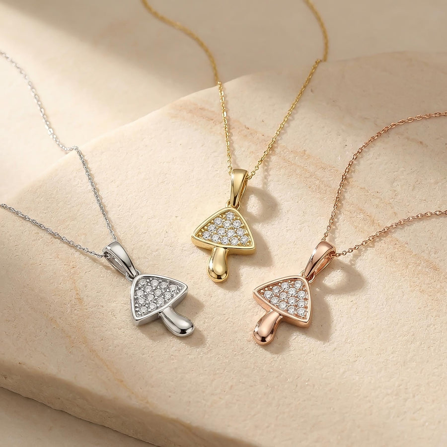 Collane con ciondolo fungo in oro bianco, giallo e rosa 14kt su una superficie di arenaria