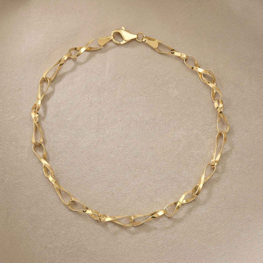 Pulsera de cadena retorcida de eslabones infinito en oro amarillo de 14 quilates extendida sobre fondo beige