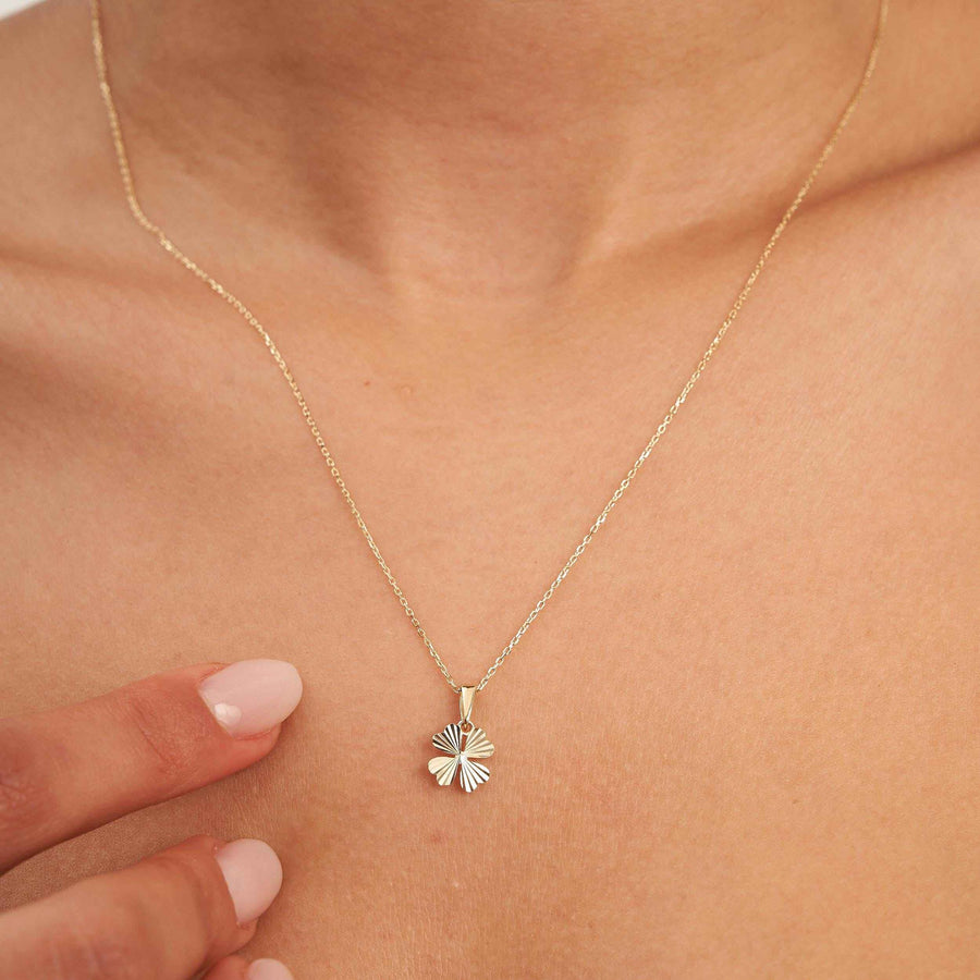 Collier trèfle à quatre feuilles taille diamant en or 14 carats porté au cou, main à proximité