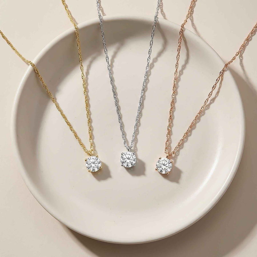 Colliers solitaires topaze blanche en or jaune, blanc et rose 14 carats sur une coupelle ronde