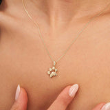 Collier empreinte de patte en or jaune 14 carats porté au cou, bout des doigts en dessous