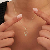 Fingerspitzen umrahmen eine Mama-und-Baby-Füßchen-Halskette aus 585er Gelbgold am Hals
